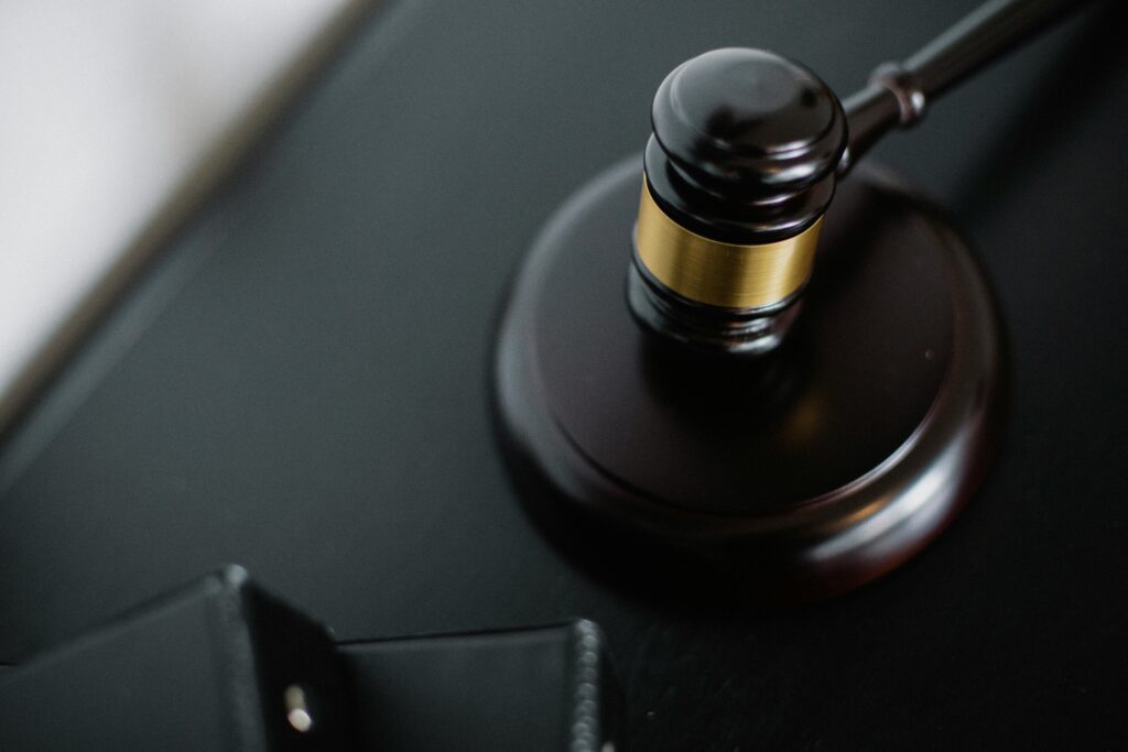 pexels-photo-5668481-5668481 Close-up of a wooden judge's gavel on a black desk, symbolizing justice and law.